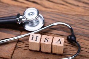 Stethoscope on wooden table with HSA letter blocks