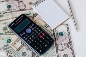 Calculator and notepad on top of money